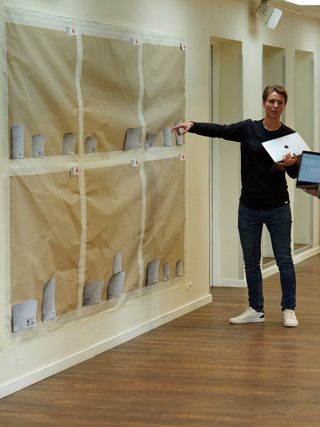 Sillan gennemgår indretningen af et butikslokale og peger på en plan på væggen.