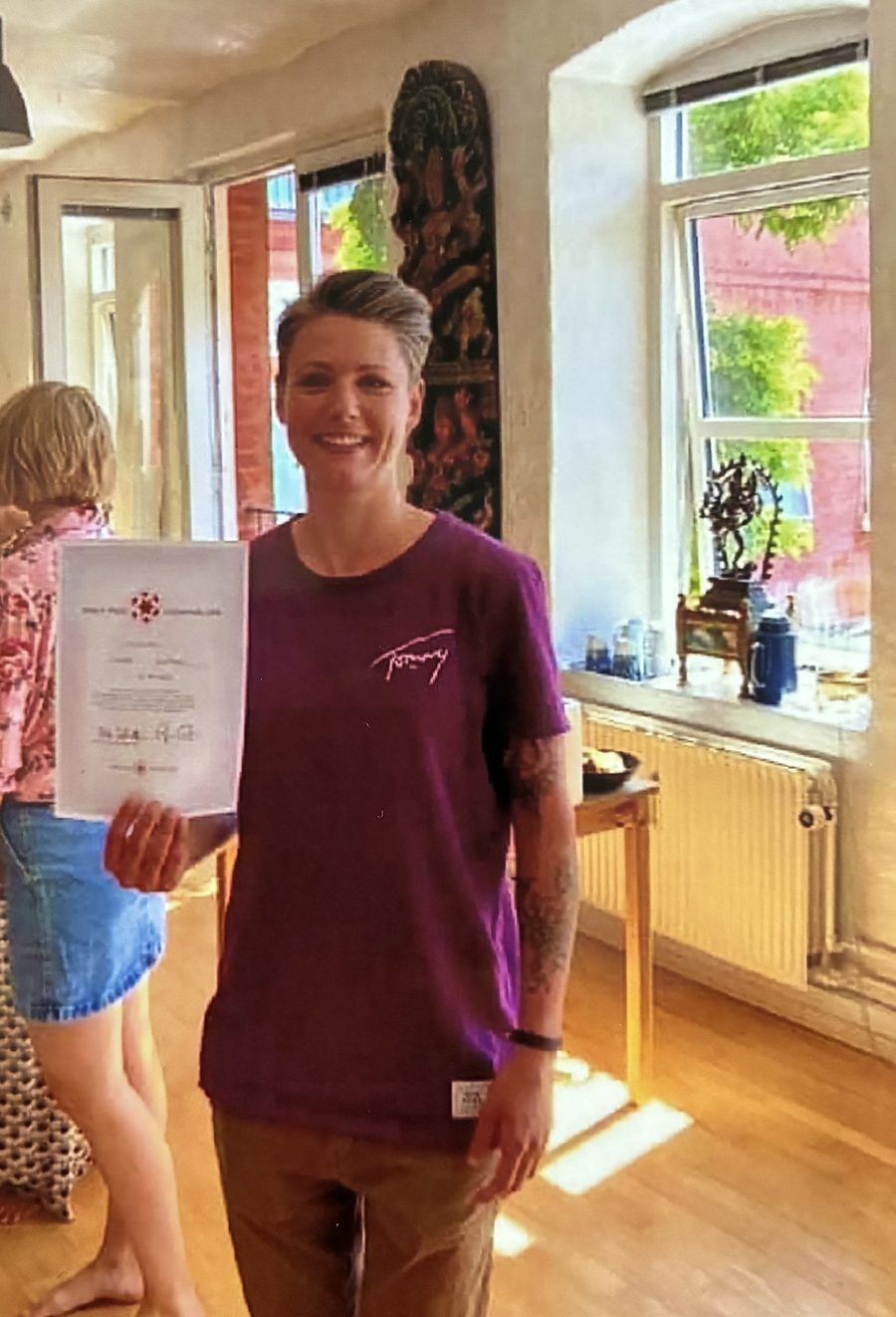 Sillan smiler og holder sit yogalærer-certifikat efter endt uddannelse.